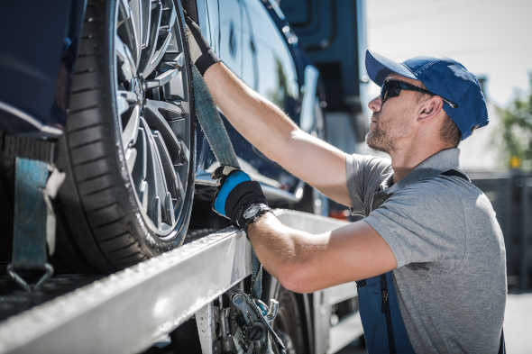 Concord Towing Service securing vehicle on flat bed